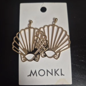 Guldiga snäckformade örhängen från Monki - Endast provade. Rengjord. Säljer då dessa aldrig kom till användning. 