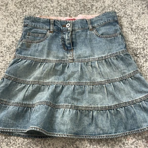 Jeanskjol med volanger från Check This - Säljer en jätte gullig blå jeanskjol från Check This i storlek 152. För kvinnor kan det också användas i storlek XS. Kjolen har volanger och klassiska jeansfickor fram samt knapp och dragkedja. Perfekt för sommaren. ❤️
