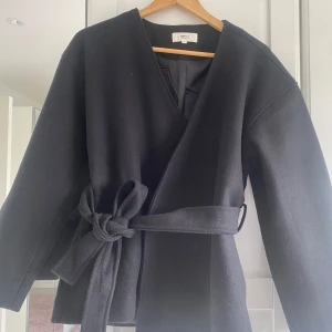 Svart kappa  - Säljer en svart kappa från Gina tricot. Perfekt för dig som gillar enkel och clean stil. Aldrig använd.