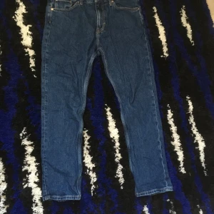 Blå jeans från Weekday - Säljer ett par klassiska blå jeans från Weekday i modellen 32/30. Jeansen har raka ben, fem fickor och stängs med dragkedja och knapp. Perfekta för en enkel och stilren look.