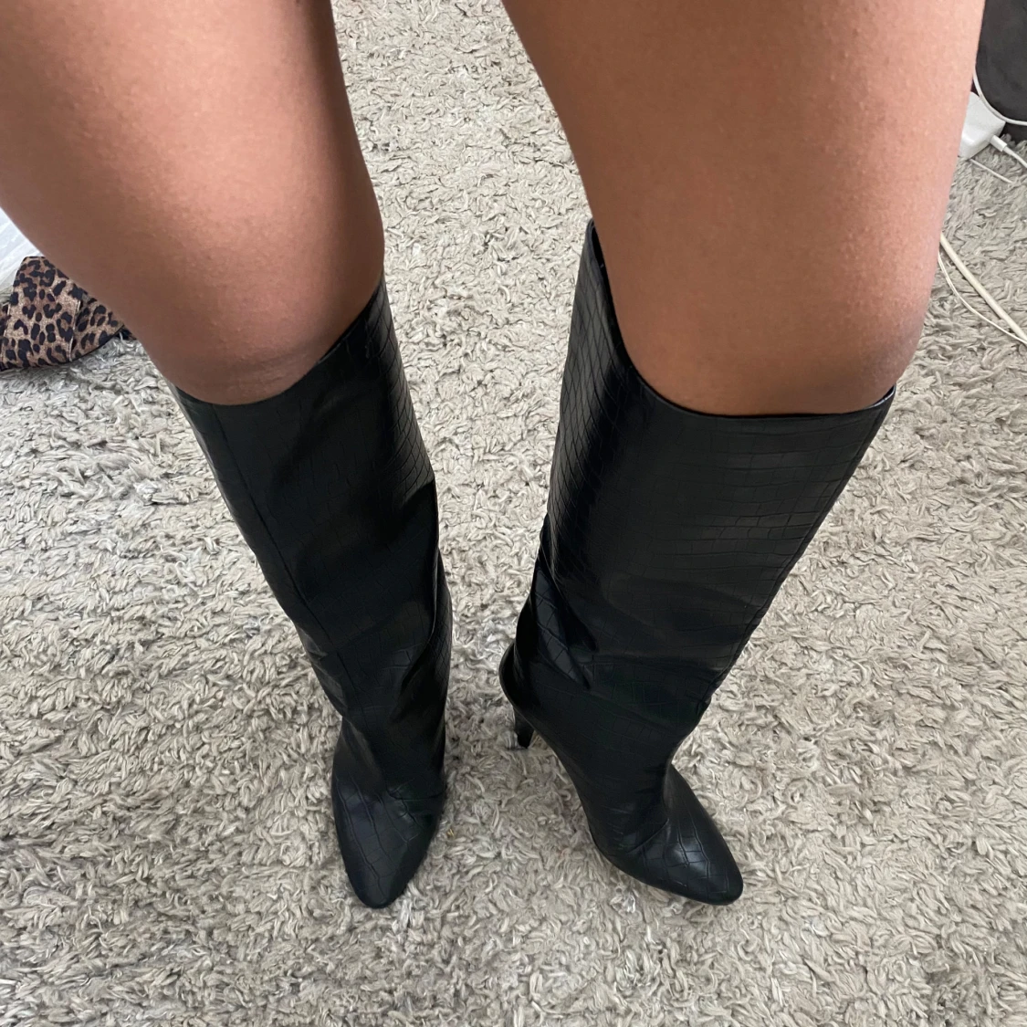 Svarta stövlar med klack och krokodilpräglat mönster