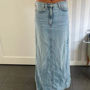 Ljusblå lång jeanskjol - Säljer min ljusblåa långkjol då den blivit för liten för mig. Kjolen har medelhög midja och stängs med dragkedja och knapp. Perfekt till sommaren! Skriv för fler bilder eller funderingar