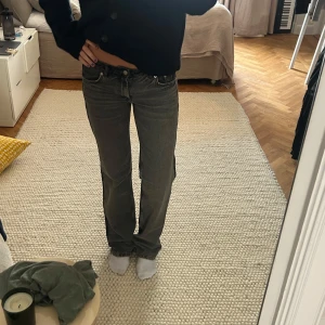 Grå bootcut jeans - Säljer ett par grå bootcut jeans med klassisk femficksdesign och normal passform. Jeansen har låg midja och raka ben med lätt utsvängning nertill. Perfekta för en avslappnad och trendig look.