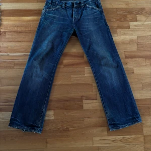 Blå jeans från G-Star RAW - Säljer ett par klassiska blå jeans från G-Star RAW med raka ben och lös passform. Jeansen har fem fickor, dragkedja och knappar i gylfen samt diskreta slitningar för en cool look. Perfekta till vardags och passar till det mesta.