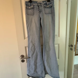 Ljusblå bootcut jeans från Queen Heart - Säljer ett par ljusblå bootcut jeans från Queen Heart med stora fickor fram och klassiska bakfickor. Jeansen har låg midja och dragkedja. Midjemått: 36 cm, Innerbenslängd: 88 cm