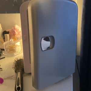 Minikylskåp  - Säljer ett smidigt sminkkylskåp i silver och vitt, perfekt för att förvara hudvård och smink. Kan ställas in på både varm och kall, drivs med både AC och DC. Perfekt till sminkbordet!