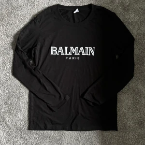 Balmain Tröja - Säljer nu en snygg Balmain tröja som är i ett jättebra skick då den är använt ett fåtal gånger, vet ej om tröjan är äkta, därav priset🙌🏼 (Priset är fast) står storlek S, men sitter med som en XS✅