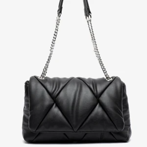 Svart quiltad axelväska med kedjerem - Snygg svart axelväska med silverfärgad kedjerem från Misako, köpt på Zalando. Väskan har en mjuk, vadderad look och är perfekt för att lyfta din outfit. Klassisk och trendig modell som rymmer det viktigaste. Använd några få gånger och i ny skick. Perfekt storlek och vid frågor är det bara att höra av sig!💕 Slutsåld!! 