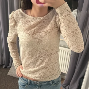 Beige spetsblus med lång ärm - Säljer en beige blus i spets med lång ärm och rund halsringning. storlek s