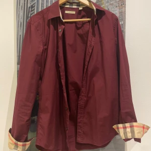 Burberry skjorta  - En burberry skjorta|vinröd färg|strl M| skick 8/10| nypris ca 1999kr| vårt pris endast:699. Vid frågor ”kontakta”📩. PERFEKT TILL SOMMAREN☀️