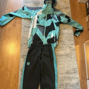 Svarta träningsbyxor med turkosa detaljer från Foot Korner - Tracksuit säljs från Foot korner. Nypris 1200 