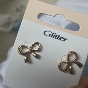 Guldiga rosettörhängen - Säljer ett par fina helt oanvända guld-pläterade örhängen :)