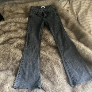 Grå bootcut jeans från Gina tricot - Säljer ett par grå bootcut jeans från Gina tricot. Jeansen har klassisk femficksdesign, bälteshällor och dragkedjegylf. Perfekta för dig som gillar en lite vidare passform nertill. Jeansen model är low waist bootcut.