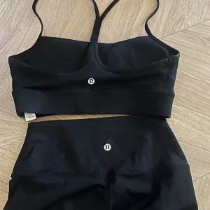 Svart set från Lululemon - Säljer ett par svarta tights från Lululemon med hög midja och stretchigt material. Samt matchande topp. Strl S