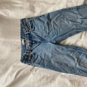 Blå jeansbyxor från Gina Tricot - Klassiska blå jeans från Gina Tricot med raka ben och normal passform. Byxorna har fem fickor, knappgylf och är tillverkade i ett robust jeanstyg. Finns små tecken på användning.