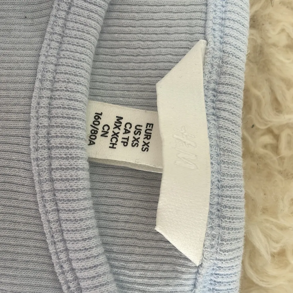 Säljer en ljusblå croppad linnetopp från H&M. Toppen är ribbad och ärmlös med rund halsringning. Perfekt för varma dagar och enkel att matcha med olika outfits.. Yläosat.