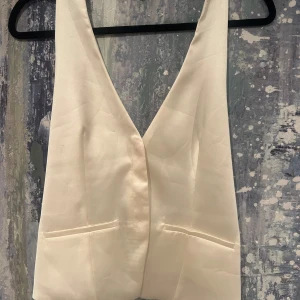 Vit topp från Zara - Säljer en stilren vit väst topp från Zara med djup v-ringning. Använd 2 gånger 🩷