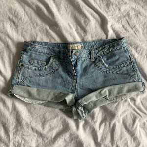 mini shorts  - Säljer ett par ljusblå jeansshorts från BONA PARTE med uppvikta benslut och klassisk femficksdesign. Shortsen har dragkedja och knapp framtill samt bälteshällor. Perfekta för varma dagar!