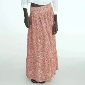 Röd mönstrig lång Zara kjol - Säljer denna långa fina kjolen ifrån Zara i storlek xs. Säljer för att den är för lång för mig. Kjolen har två defekter där det har blivit små hål som knappt syns när man har på sig den då det blev hål i tvätten, bara att skriva ifall man vill ha bilder!🥰