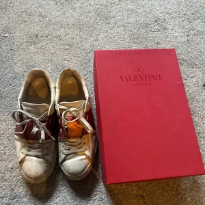 Valentino Garavani sneakers med röd detalj - Säljer ett par limited edition skor från Valentino Garavani med röda detaljer ( denna färg säljs inte längre) . Kommer med orginalkartong, dustbag. Tvättas & fräschas självklart upp när de blivit sålda :) 