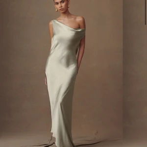 Ljusgrön balklänning i satin - Elegant balklänning i ljus champagnefärgad satin med one shoulder och öppen rygg. Klänningen har en mjukt draperad passform. Perfekt till Balen! Oanvänd med prislapp kvar🥰