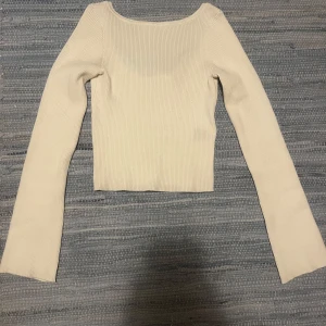 Vit ribbad långärmad topp från H&M - Säljer en vit ribbad långärmad topp från H&M. Toppen har en croppad passform och öppen rygg. Jättebra skick i storlek 146/152