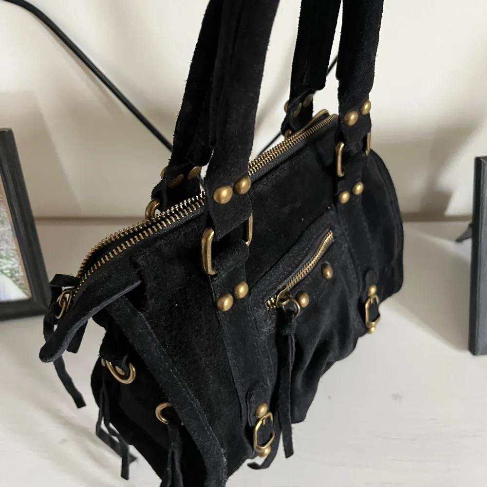 Balenciaga liknande väska, med fint material och knappast använd. Osäker på märket men köpte på Raglady för 1300. Kommer med ett längre band. Man kan även ta av de svarta snören som hänger. Kontakta mig innan ni köper!!! Kommer inte gå ner i pris . Laukut & Käsilaukut.