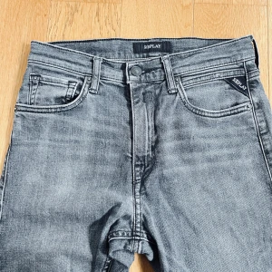 Replay grå jeans straight fit - Snygga grå jeans från Replay med klassisk femficksdesign och raka ben. Jeansen har en tvättad look och tydliga sömmar på bakfickorna. Barnmodell.