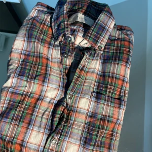 Rutig skjorta från M. Grifoni, strl 39 - Snygg rutig skjorta från M. Grifoni i flera färger som blå, röd, grön och vit. Skjortan har klassisk krage, bröstficka och knäppning framtill. Perfekt för dig som gillar en färgstark och tidlös look. Långärmad och i mjuk bomull.