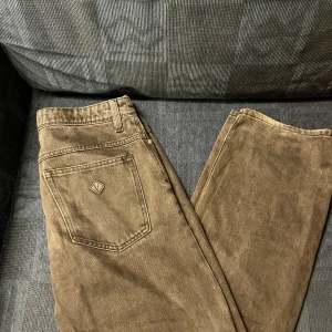 Abrand jeans 30/32 - Säljer ett par snygga gråa jeans med klassisk rak passform. Byxorna har en bakficka med en liten logga och bälteshällor i midjan. Perfekta för dig som gillar normal stil och vill ha något som sticker ut i mängden!