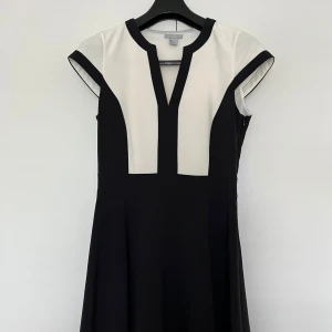H&M svartvit klänning, storlek 40 - Elegant svart och vit klänning med en unik design från H&M i storlek 40. Klänningen har korta ärmar och en figursmickrande silhuett. Perfekt för både vardag och fest. Tjock material i 93% polyester och 7% elastan samt fodret i 100% polyester. Stängning med diskret dragkedja på vänster sida.  Nyskick.   Mått:  Längd ca 95 cm Byst ca 43 cm Midja ca 38 cm Ärmlängd mätt från axeln ca 10 cm Axel till axel ca 37 cm