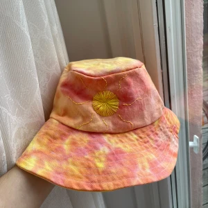 Fiskehatt sol - Fiskehatt i solnedgångafärger med broderad sol