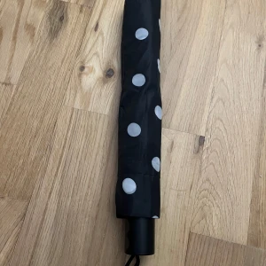 Paraply - Säljer ett vit svart prickigt paraply med fodral till. Helt nytt