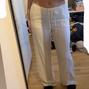 Vita beige vida linnebyxor - vita beige linnebyxor med bred passform och dragsko i midjan. Byxorna är medel i midjan och har en avslappnad, loose fit. Perfekta för varma dagar och chill vibes. Materialet är svalt och luftigt linne. Från H&M. Använd 2 gånger. Inte så genomskinliga om man har vita trosor. Passar M och S. 