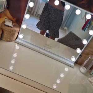 Blå blommig omlottkjol med volang - Supersöt blå kort omlottkjol med vitt blommönster och volangkant. Kjolen knyts i sidan för en snygg passform och har en flowy känsla som passar perfekt till varma dagar. Lätt och luftig, perfekt för dig som gillar en feminin och trendig stil.