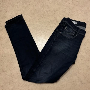 Replay anbass jeans - Snygga mörkblå Replay Anbass jeans med klassisk femficksdesign och diskreta slitningar. Jeansen har smal passform, gul kontrastsöm och logga på bakfickan. Perfekta för dig som gillar stilrena och moderna jeans med en cool vibe. Skick 8-9/10, använda men bra skick. Fråga gärna.