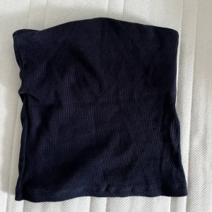 Mörkblå ribbad tubtopp - Snygg mörkblå ribbad tubtopp i bandeau-modell. Perfekt att styla med höga jeans eller kjol för en trendig look. Toppens ribbade material ger en cool struktur och sitter skönt mot kroppen. Toppen är från H&M o är endast testad ☀️