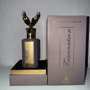 Emir Fascination Celestial Series parfym - Lyxig parfym från Emir Celestial Series, Fascination. Flaskan är matt grå med gulddetaljer och har ett unikt lock i form av gyllene vingar. Kommer i en elegant ask med guldinslag. Perfekt för dig som gillar exklusiva och iögonfallande dofter.                                     100ml flaska, enbart testad och det är ett bra pris för innehållet i flaskan.