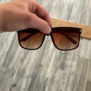 Liknar raybans boyfriend  - Snygga solglasögon med fyrkantig form och bruna bågar. Glasen är tonade i brunt och ger en cool retrovibe. Perfekta för att lyfta din stil under soliga dagar.