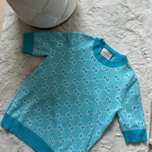 Turkos/blå Gucci tröja - Tröja från Gucci med korta ärmar och vit logga över hela plagget.  