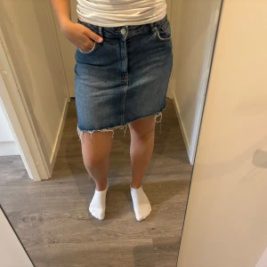 Blå jeanskjol  - Säljer en blå jeanskjol med lite slitningar längst ner. Super bekväm passform då den är i stretch! Säljer då jag har en annan likadan😊Skriv vid fler bilder eller funderingar!