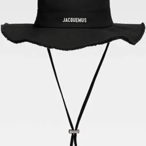Svart Jacquemus bucket hat med snörning - Stilren svart bucket hat från Jacquemus med bred, fransad brätte och justerbar snörning under hakan. Perfekt accessoar för att lyfta din look.