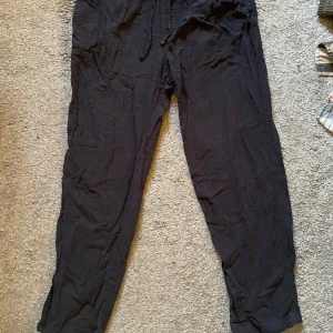 Svarta linnebyxor  - Svarta linneaktiga mjukisbyxor med elastisk midja. Byxorna har en avslappnad passform och är tillverkade i ett mjukt material som passar perfekt för en chill dag hemm.