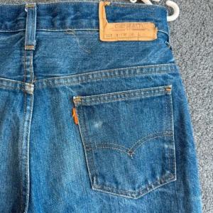 Levis 527 blå jeans - Klassiska blå Levis 527 jeans med raka ben och knappgylf. Tidlös modell med fem fickor och Levis-lapp bak i midjan. Perfekta för dig som gillar vintagekänsla och ikonisk denimstil.