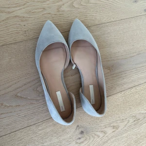 Ljusgrå ballerinaskor med spetsig tå - Säljer ett par ljusgrå ballerinaskor i mocka med spetsig tå💌