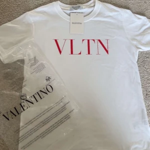Vit t-shirt från Valentino med röd VLTN-logga - Säljer en vit t-shirt från Valentino med röd VLTN-logga på bröstet i storlek M. Klassisk rund halsringning och normal passform. Tillverkad i mjuk bomull och levereras med originalförpackning och tagg. pris kan diskuteras 