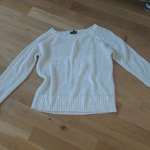 Vit stickad  ihålig tröja med stjärnmönster - Säljer en vit stickad tröja med lång ärm och ett stort stjärnmönster framtill. Tröjan har en luftig, hålstickad design och bred ribbad kant nedtill och vid ärmsluten. Perfekt för lager-på-lager och en avslappnad stil.