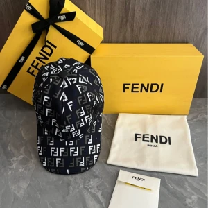 Svart och vit keps från Fendi - Snygg svart keps från Fendi med vitt FF-mönster över hela kepsen. Klassisk böjd skärm och justerbar passform. Perfekt accessoar för att lyfta din outfit med en lyxig touch. 800 kr styck 