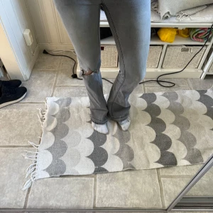 Gråa bootcut jeans med slitning - Säljer ett par gråa jeans med bootcut passform och slitning vid ena knät. Jeansen har klassiska fickor och normalhög midja. Perfekta för en avslappnad och trendig look. Storlek:15 år/167, köpta från kids brandstore.