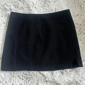 Kort Kjol - Säljer en svart kort kjol från Boohoo med slits på sidan. Aldrig använd och prislapp är kvar. Skriv för frågor❤️